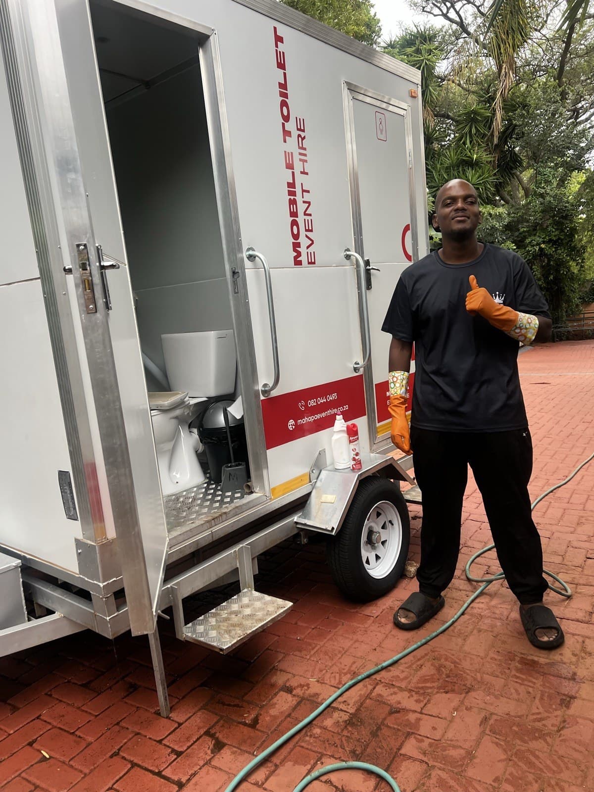 Mahapa Event Hire founder cleaning and servicing a VIP mobile toilet trailer before delivery